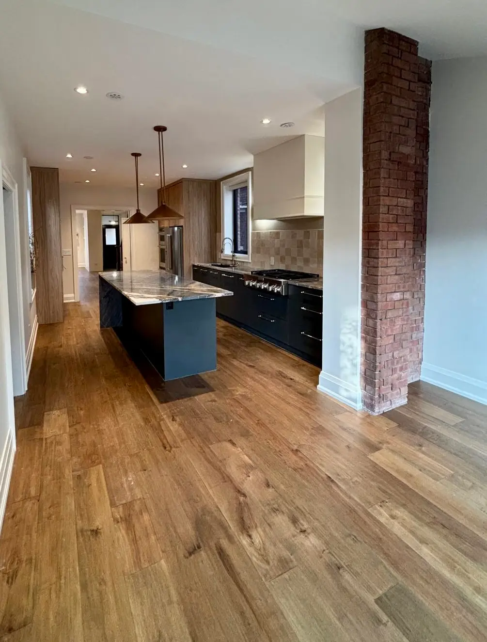 Kitchen with warm hardwood and exposed brick