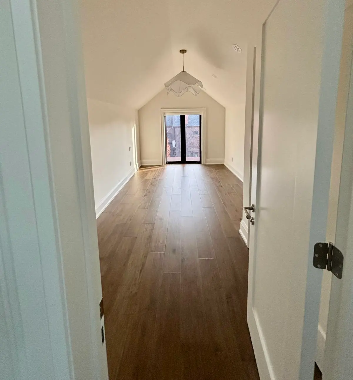 Vaulted hallway with dark hardwood