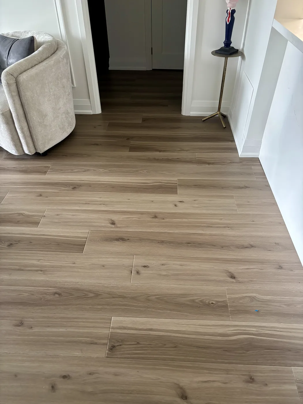 Wide-plank oak flooring running through a residential hallway